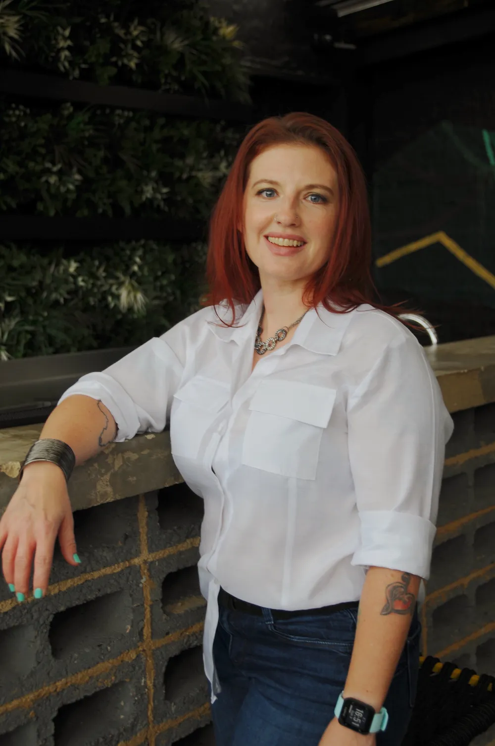Jamie Gantt smiling, leaning on a wall