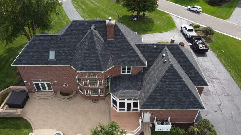 After: finished estate home with new dark shingle roof