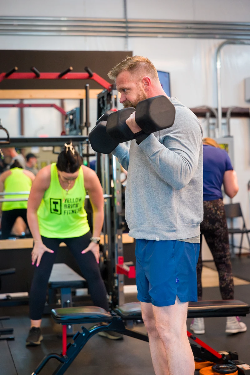 A man curls dumbells at Yellow Brick Fitness in White House, TN