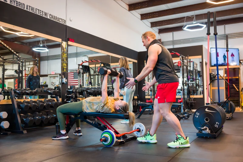 A new member of Yellow Brick Fitness is helped during her workout by Jeff Caldwell, owner and trainer