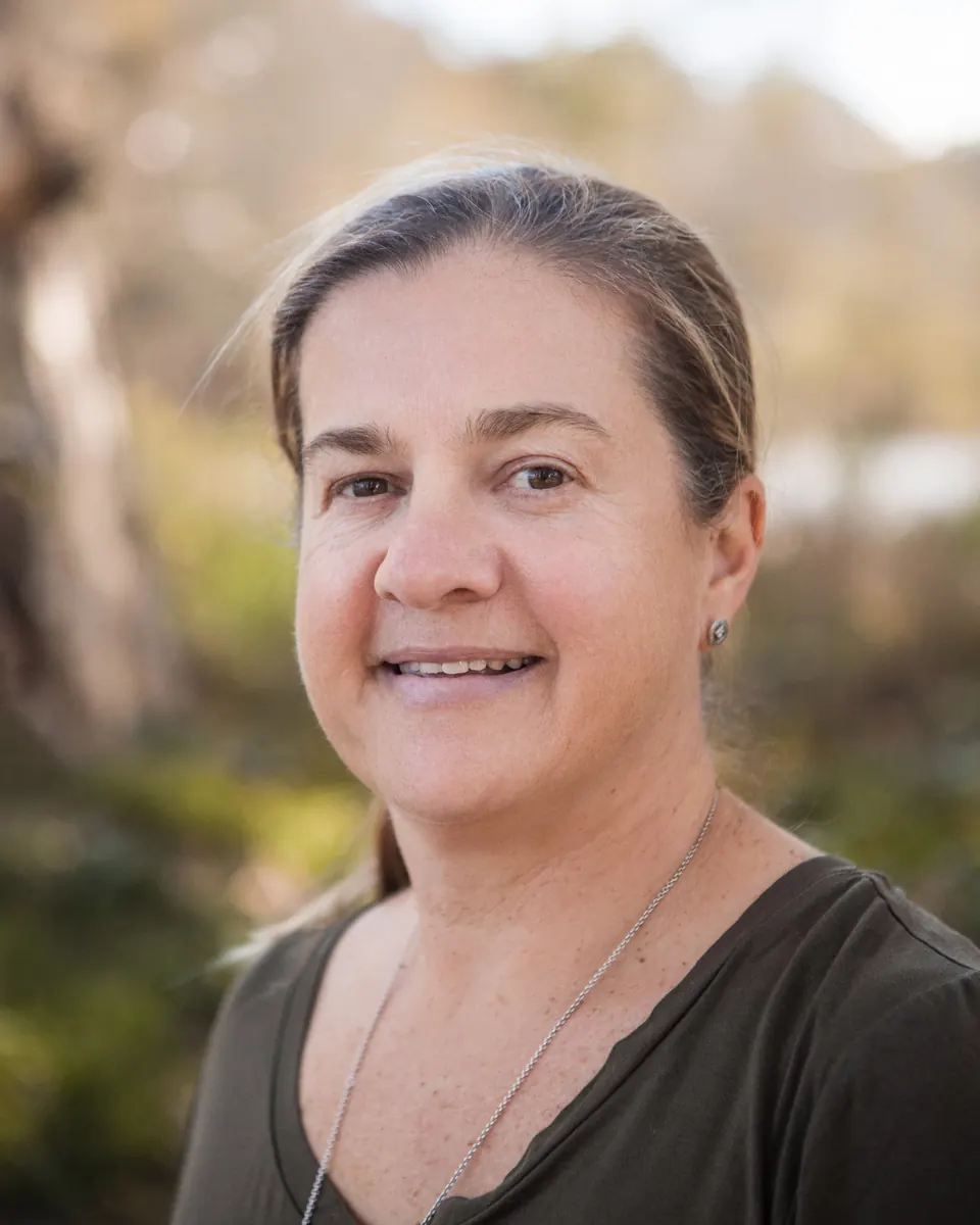 Portrait of Tammy Schwarzl smiling, with Central Coast bushland behind her