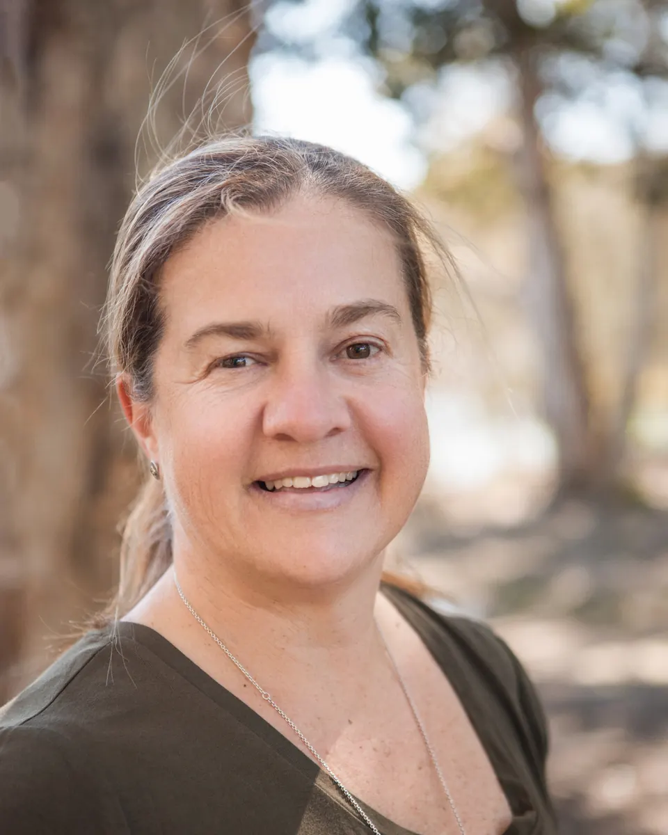 Close portrait of Tammy smiling outdoors in soft afternoon light
