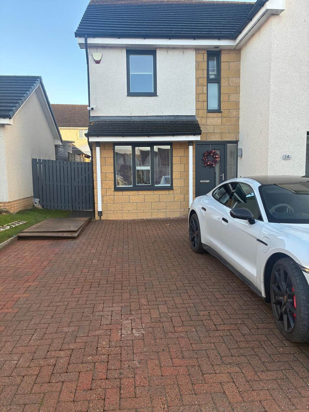Front of a house after a garage conversion, garage opening infilled with a new window and front door