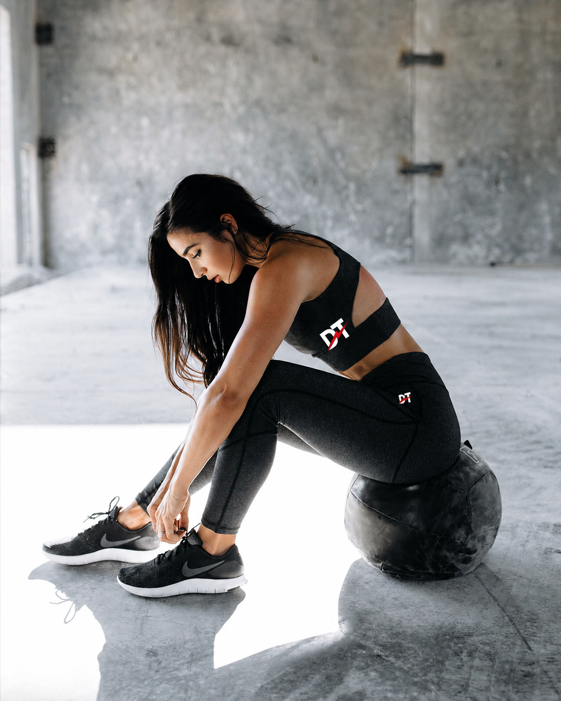Woman tying shoes in gym