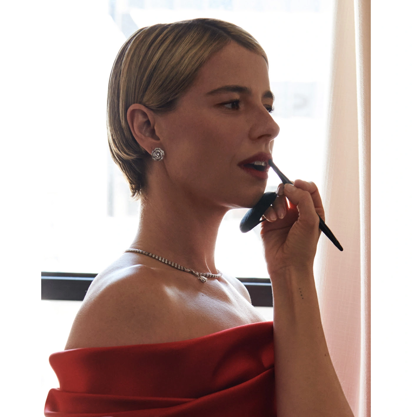 Jessie Buckley wearing CHANEL beauty at the 98th Oscars with a radiant complexion and blurred red lip