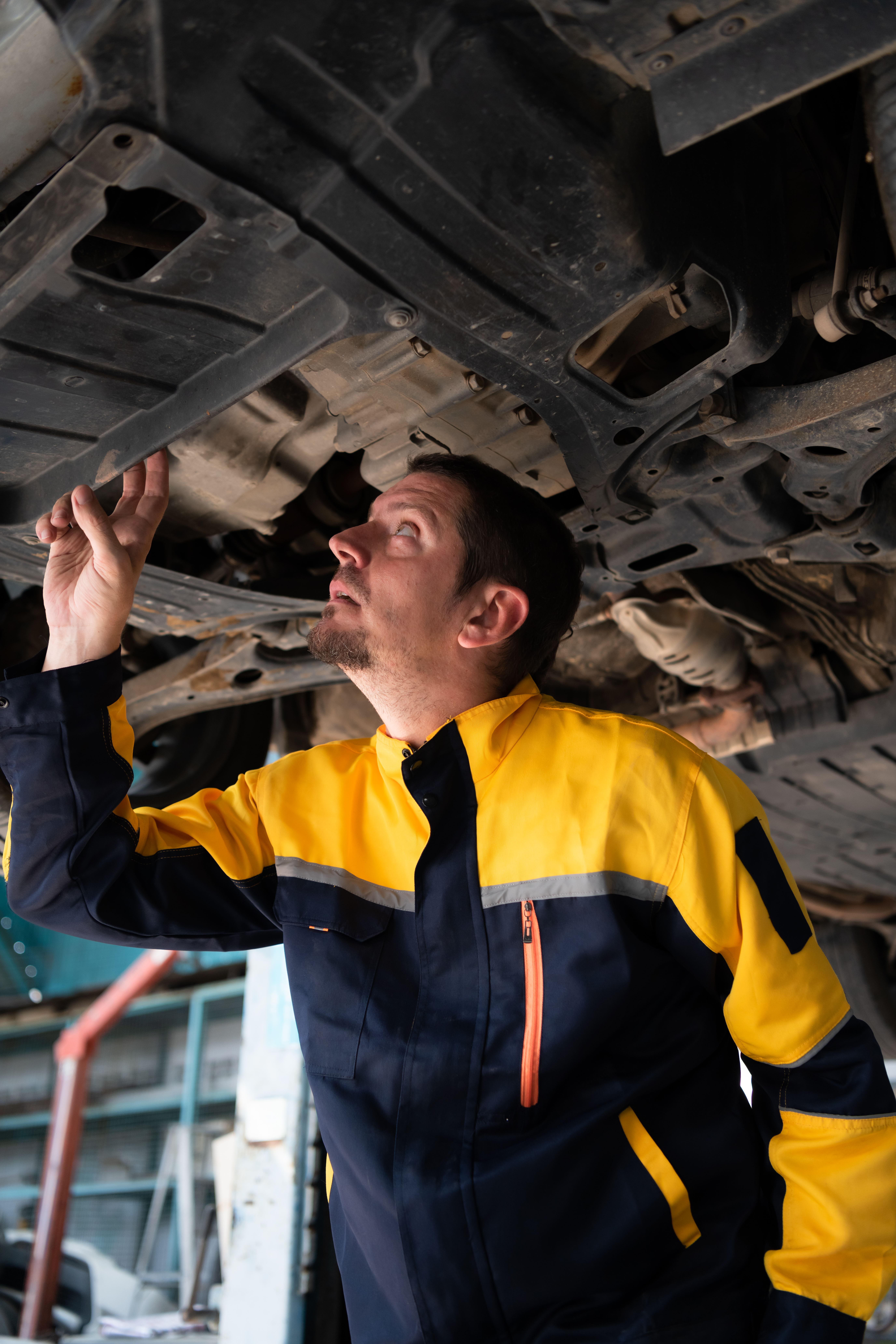 Exhausted male mechanic in an Aussie workshop with dashboard overlay showing bookings, reviews, and missed calls.
