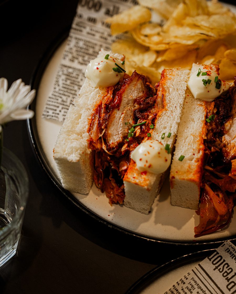 Fried Chicken Sando on shokupan with gochujang glaze, kimchi slaw and crisps