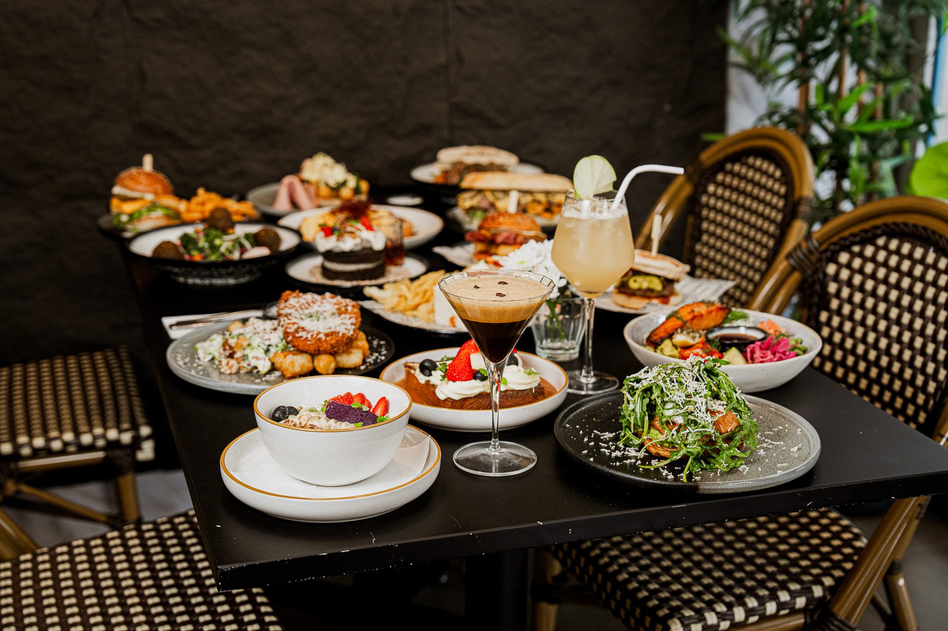 A table at Danka Café & Lounge Parramatta set with brunch plates, an espresso martini mocktail and a Sinking Dusk mocktail