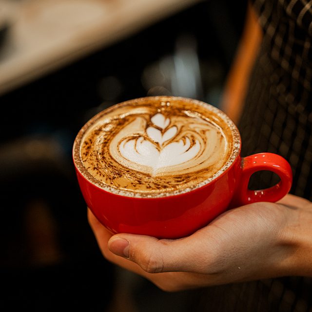 Latte with rosetta art served in Danka's red cup