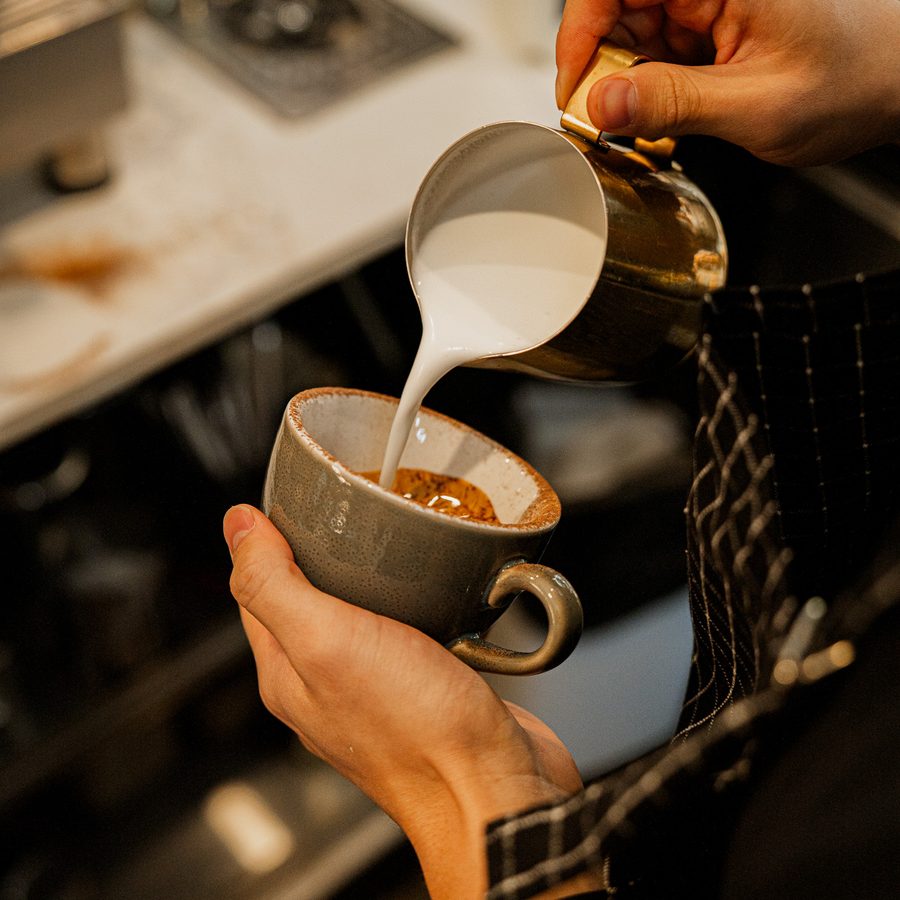 A Danka barista pouring latte art into a cup
