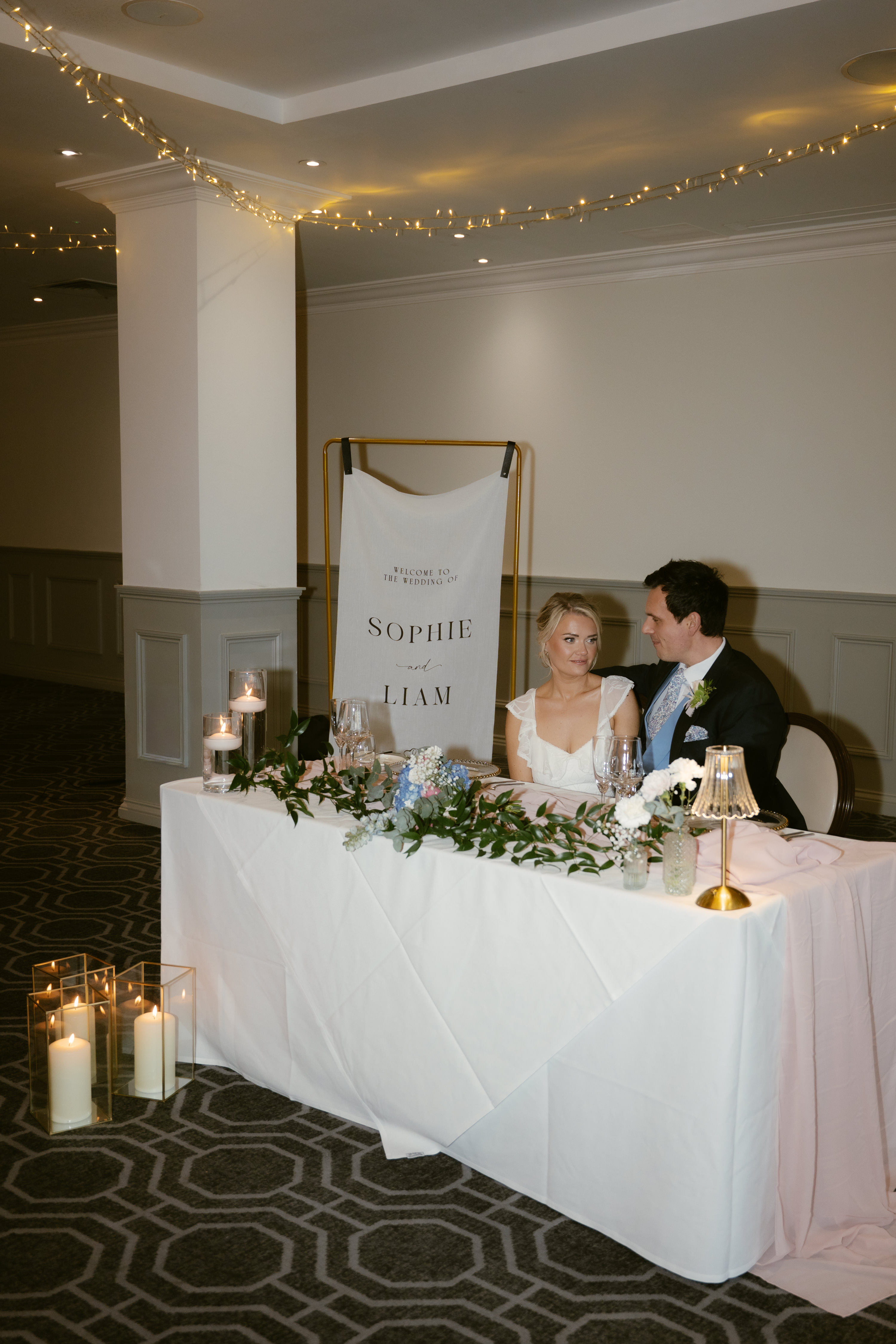 Bride and groom at sweetheart table Bridgerton styled shoot De Vere Wokefield Estate Berkshire Bride and groom at sweetheart table Bridgerton styled shoot De Vere Wokefield Estate Berkshire