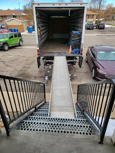 Apartment movers in Fort Collins carrying furniture into an apartment building