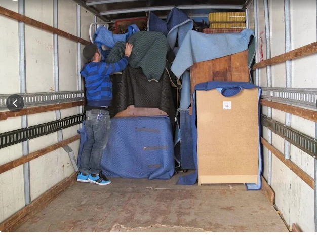 Fort Collins movers wrapping and protecting furniture before loading it onto a moving truck