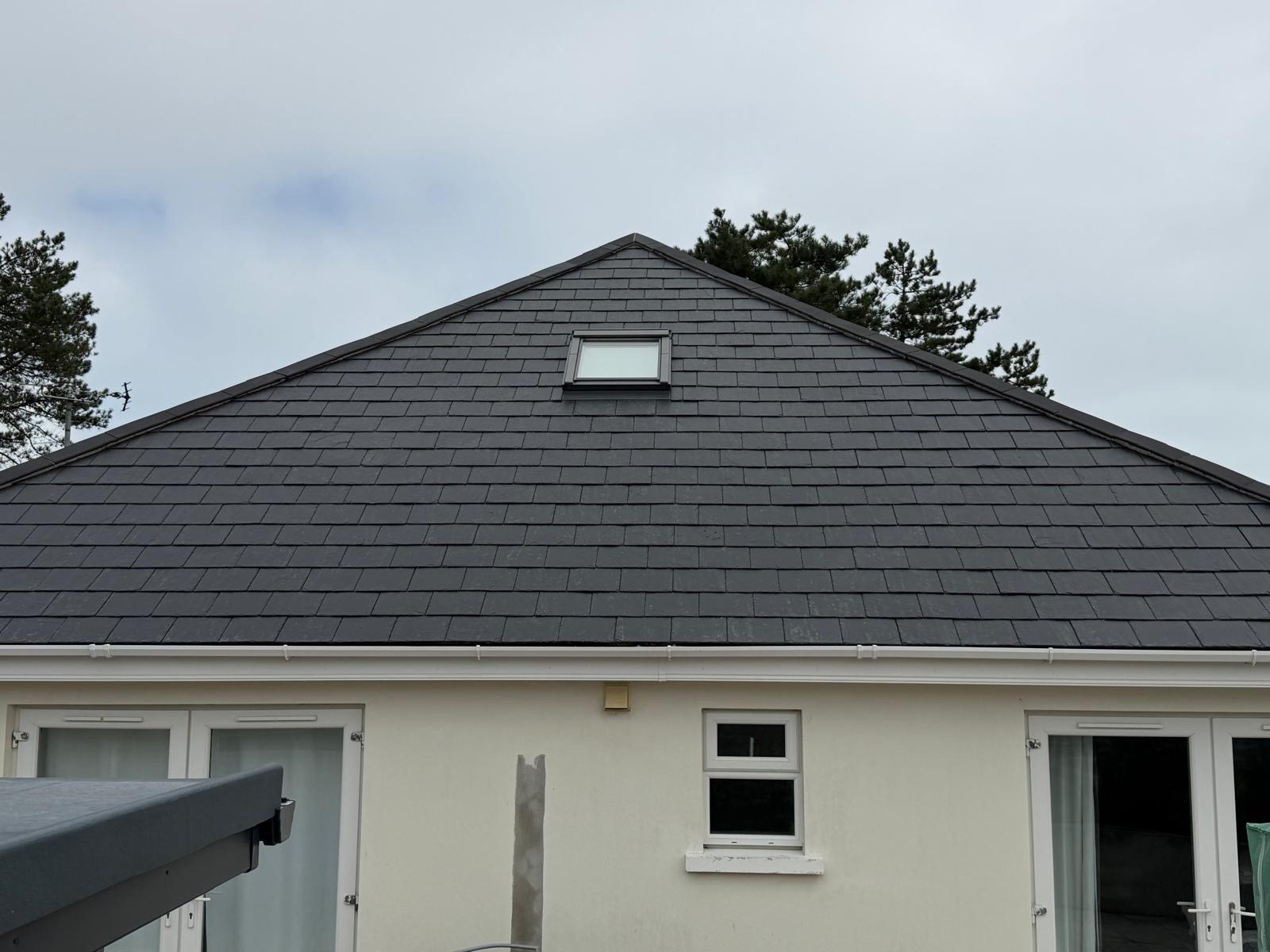 Front view of a property with a clean, even dark grey roof after cleaning.