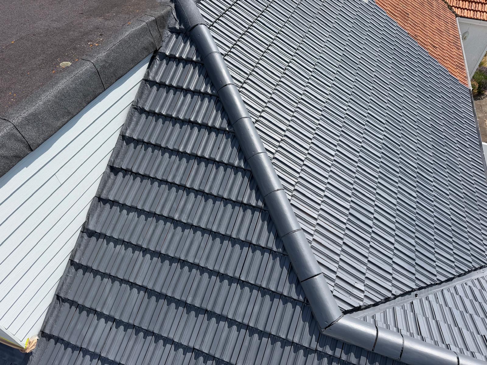 Restored roof with an even dark grey finish after treatment.