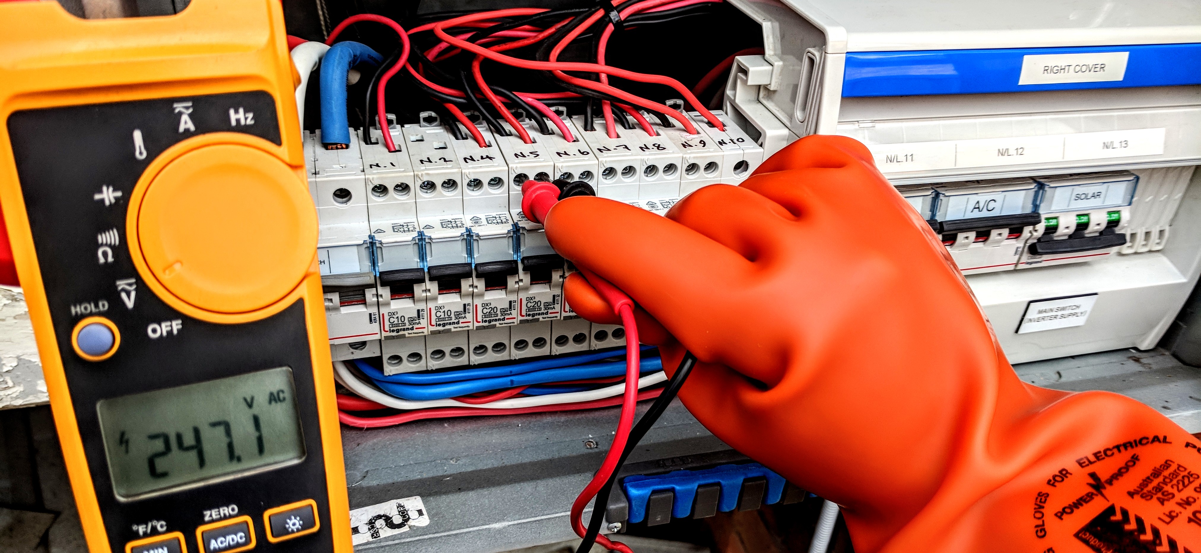 Electrical testing instruments connected to inverter terminals during a solar system assessment.