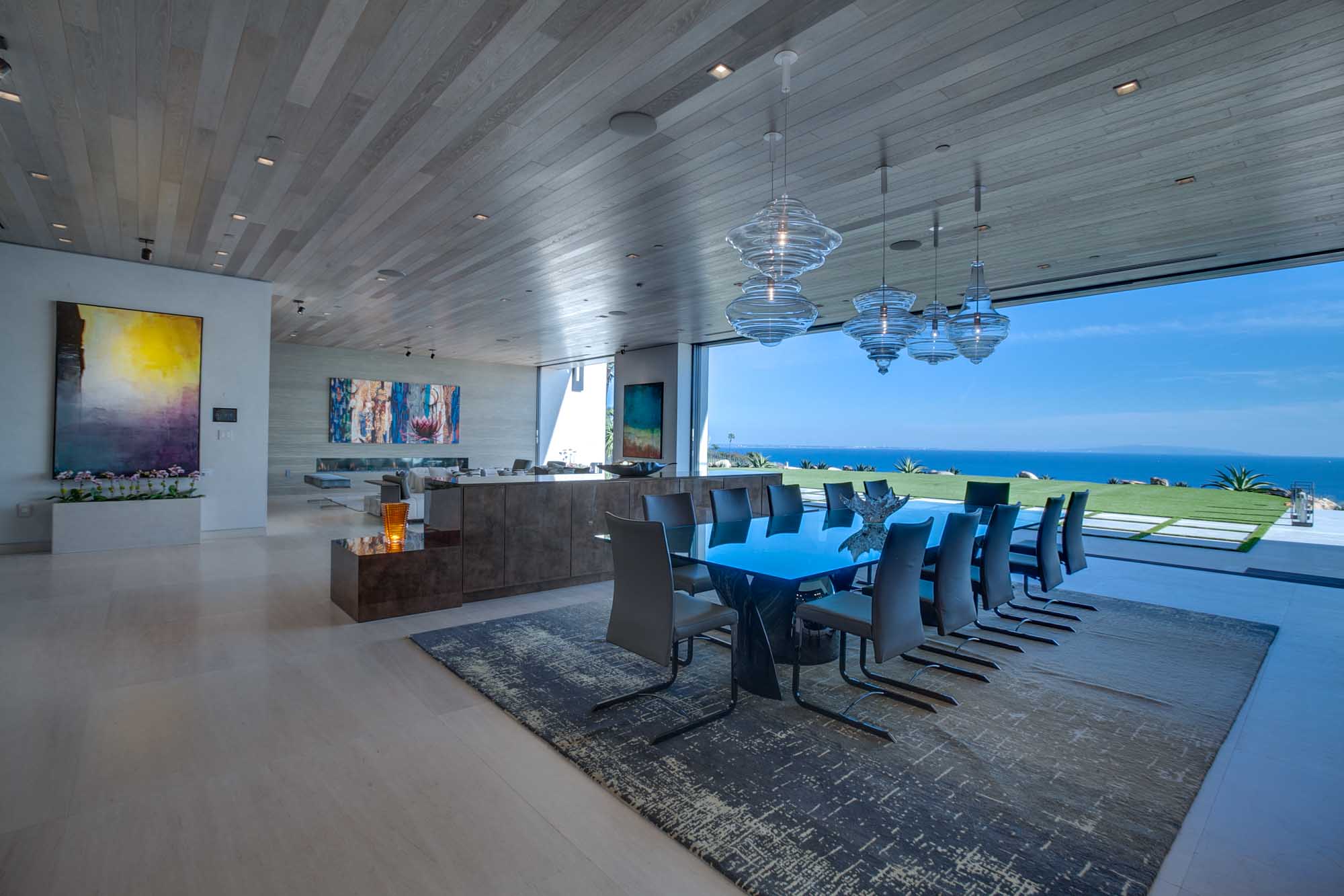 Luxury Dining and Living Space with Floor to Ceiling Glass and Panoramic Ocean Views.