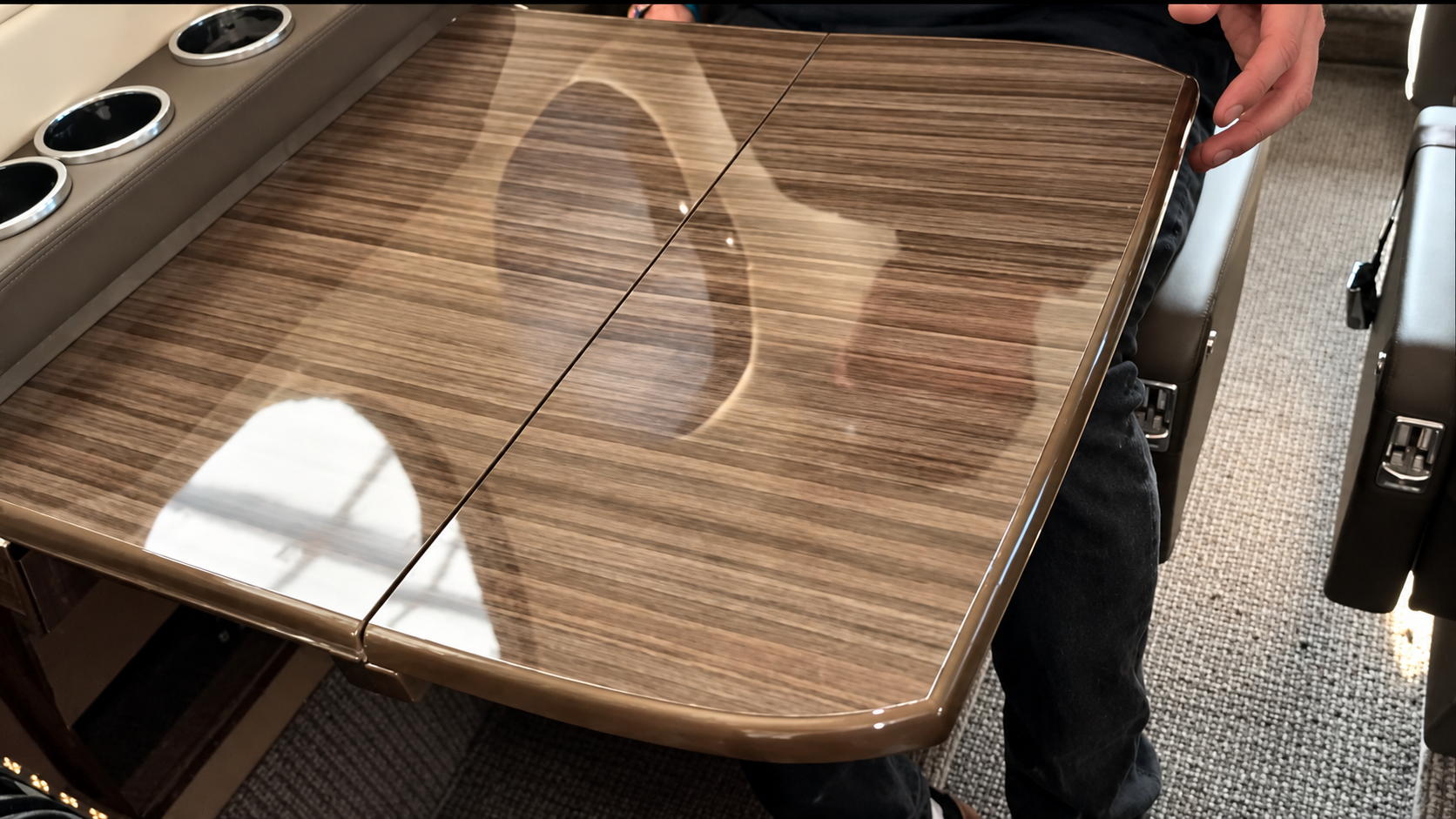 Detailer vacuuming and cleaning aircraft cabin carpet