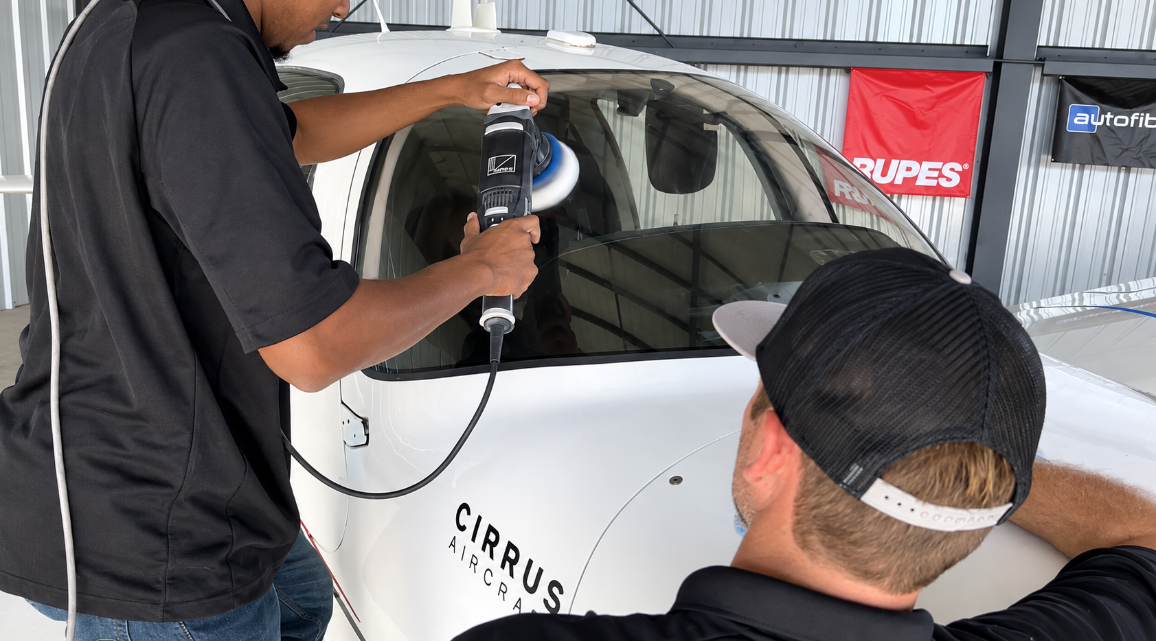 Technicians machine polishing and correcting aircraft surfaces on a Cirrus aircraft