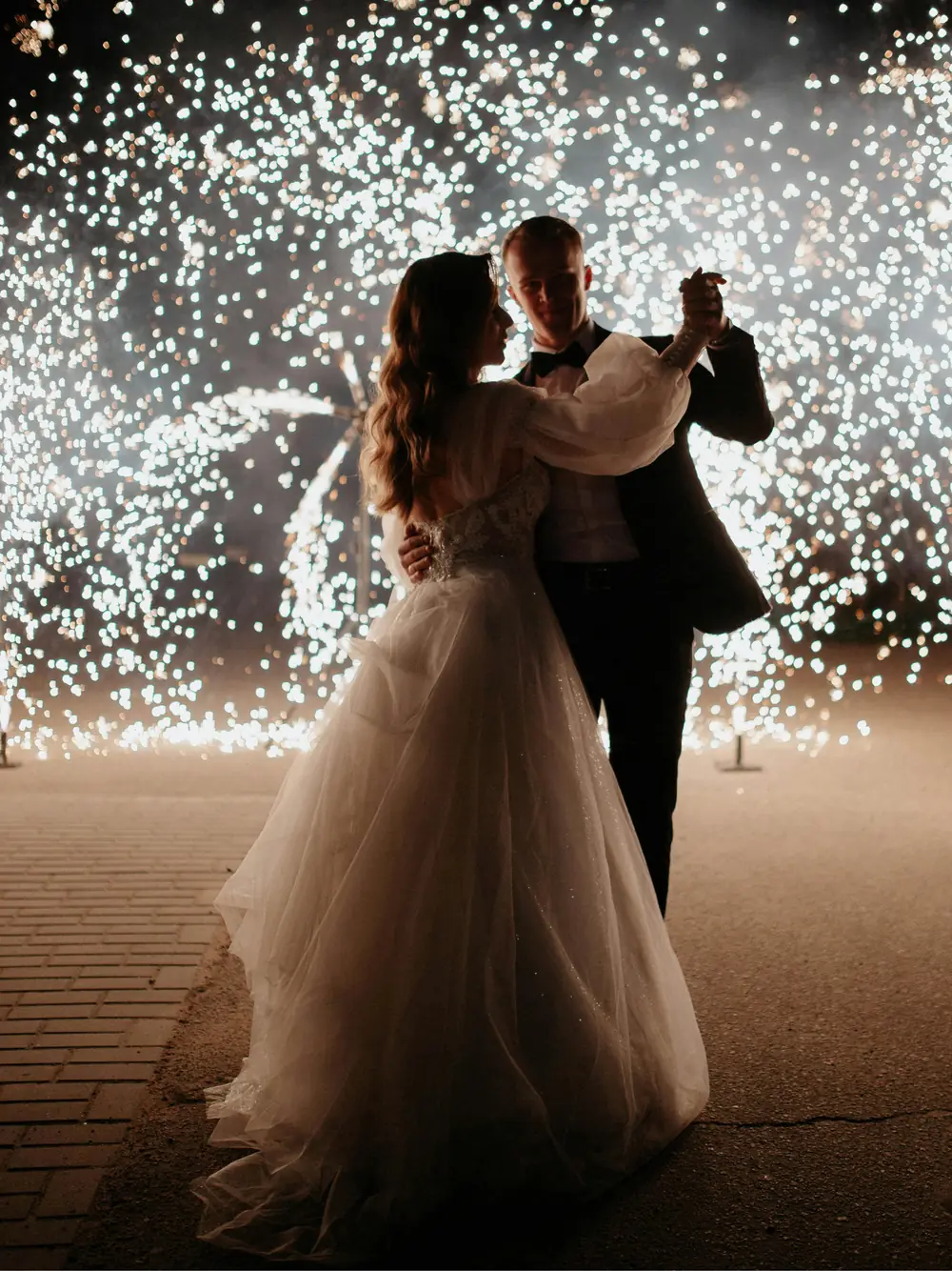Bride and groom sharing their first dance under sparklers