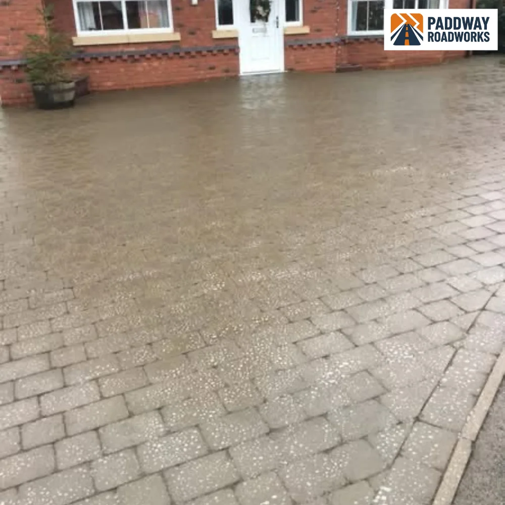 Block-paved driveway in front of period bay-window house.