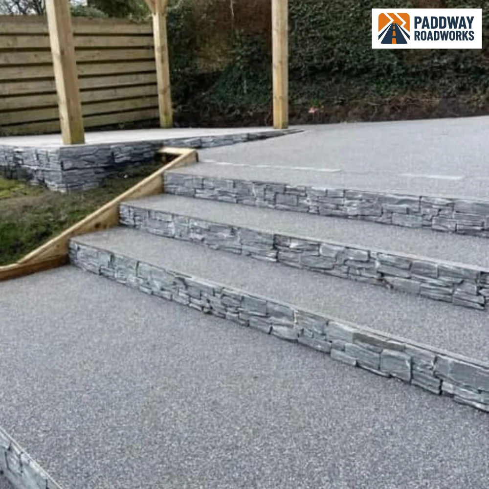 Resin-bound steps with stacked-stone risers — premium decorative finish.
