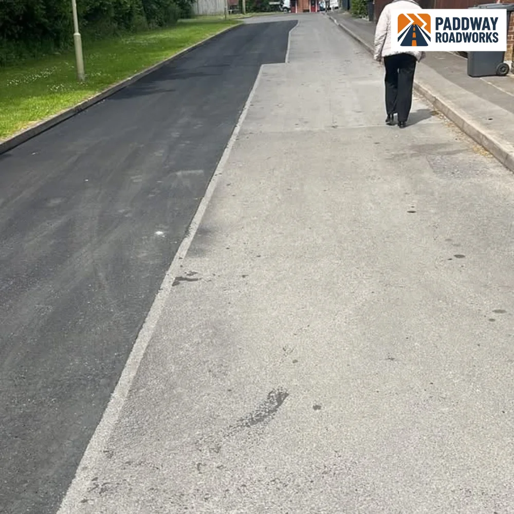 Tarmac alley driveway finished, person walking distantly.