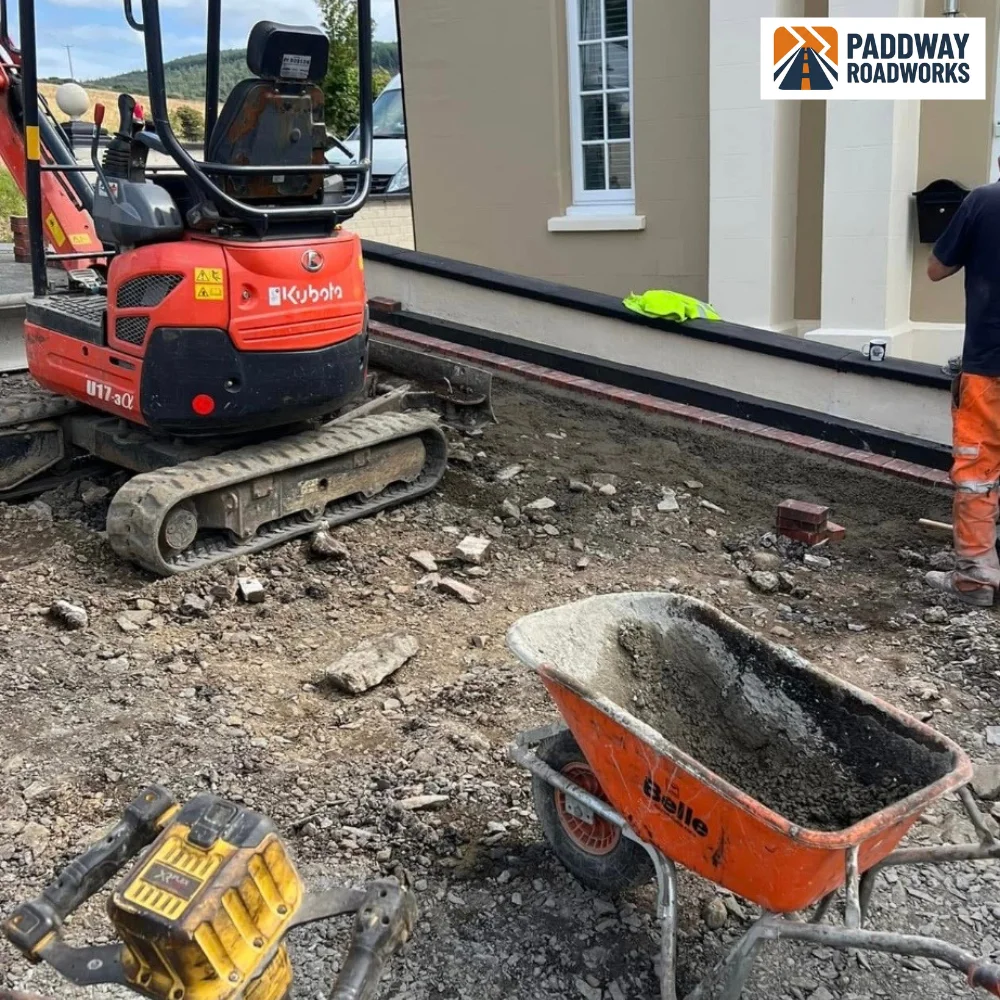 Excavation in progress with red Kubota mini-excavator and groundworker.