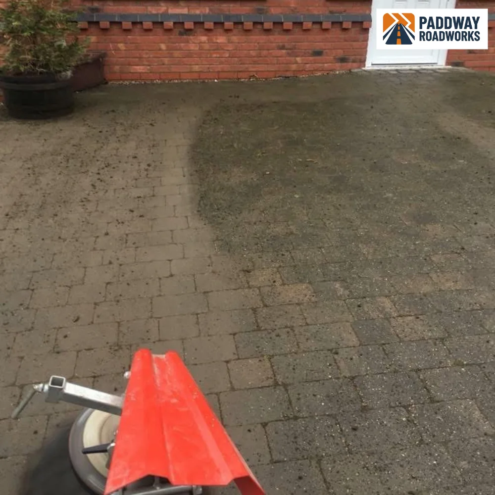 BEFORE — block paving with green moss, half pressure-washed showing dramatic clean contrast.