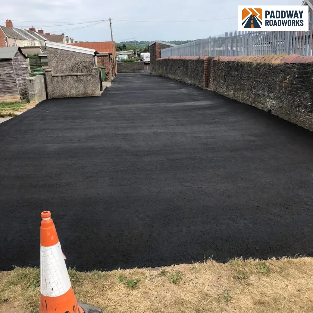 Tarmac forecourt finished with traffic cones marking the wet edge.
