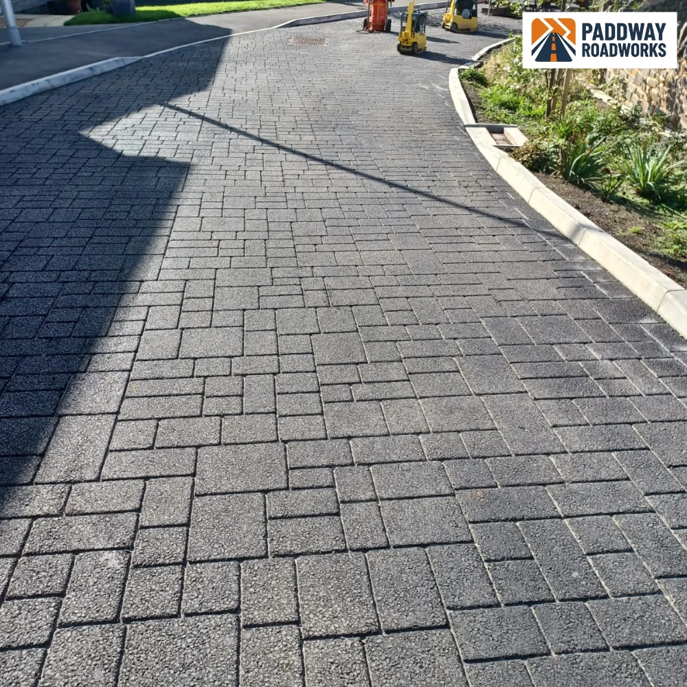 Finished herringbone block-paved residential driveway with granite kerb edge.