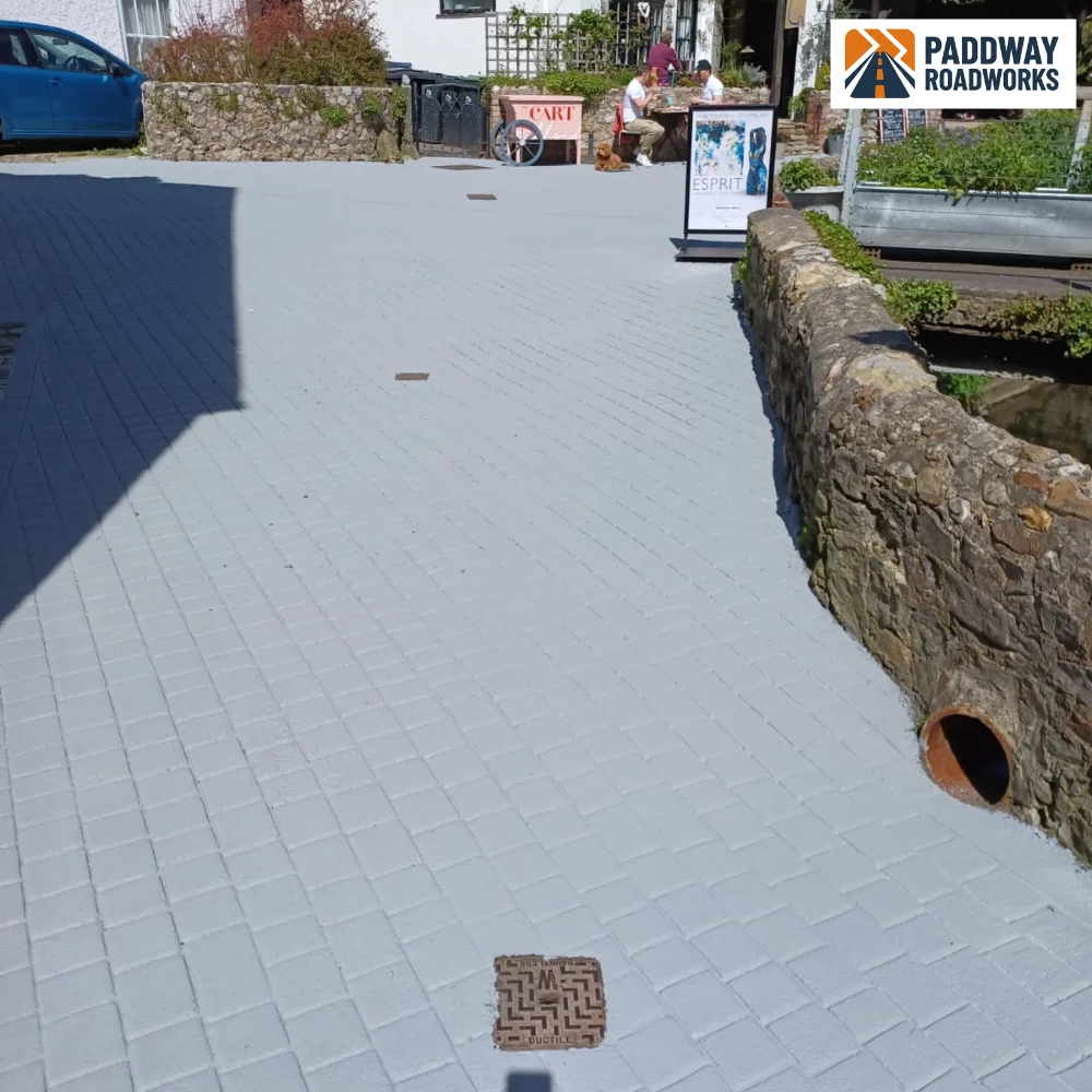 Block-paved courtyard bordered by stone wall and granite kerb.