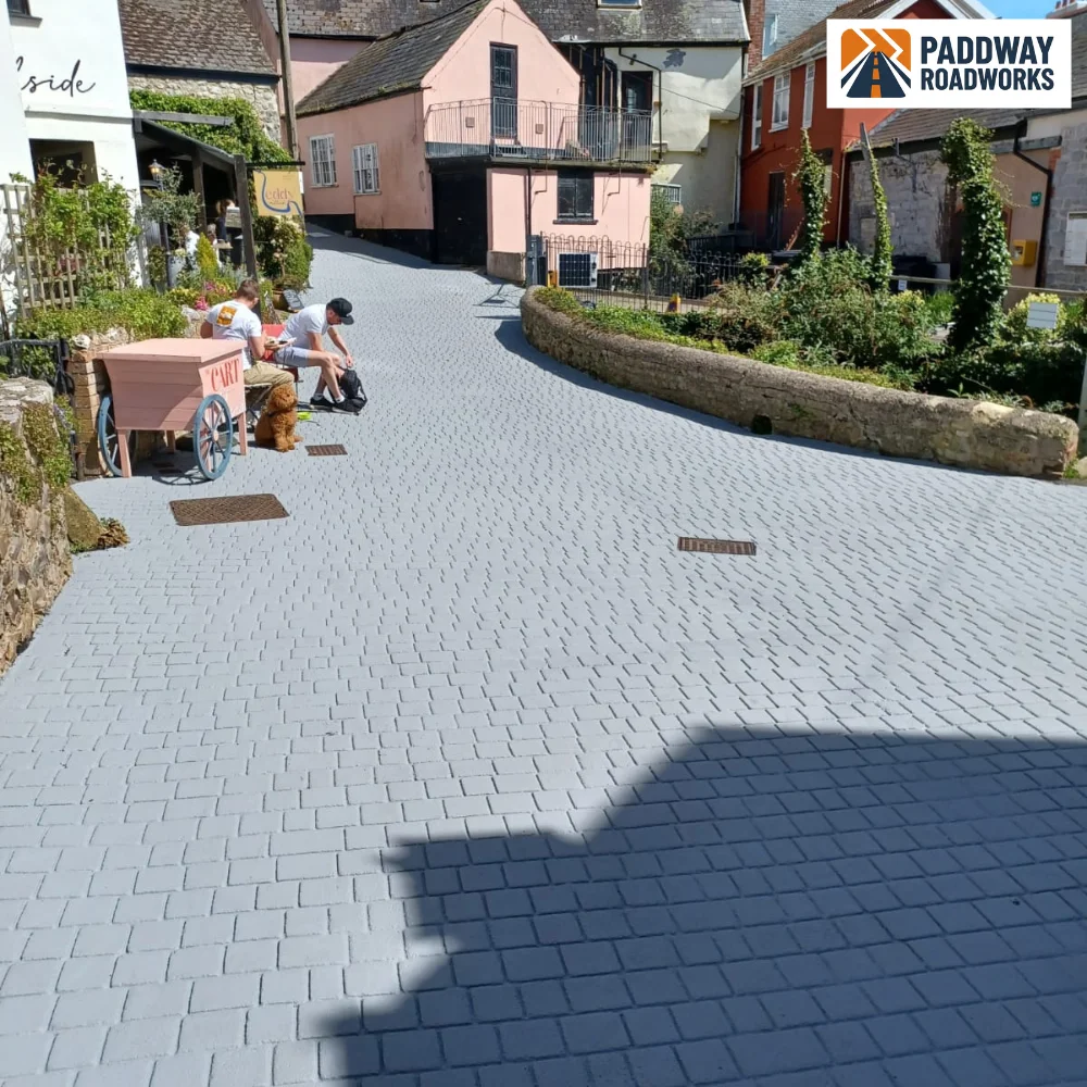 Sloped block-paved alley with traffic-management chair in place.