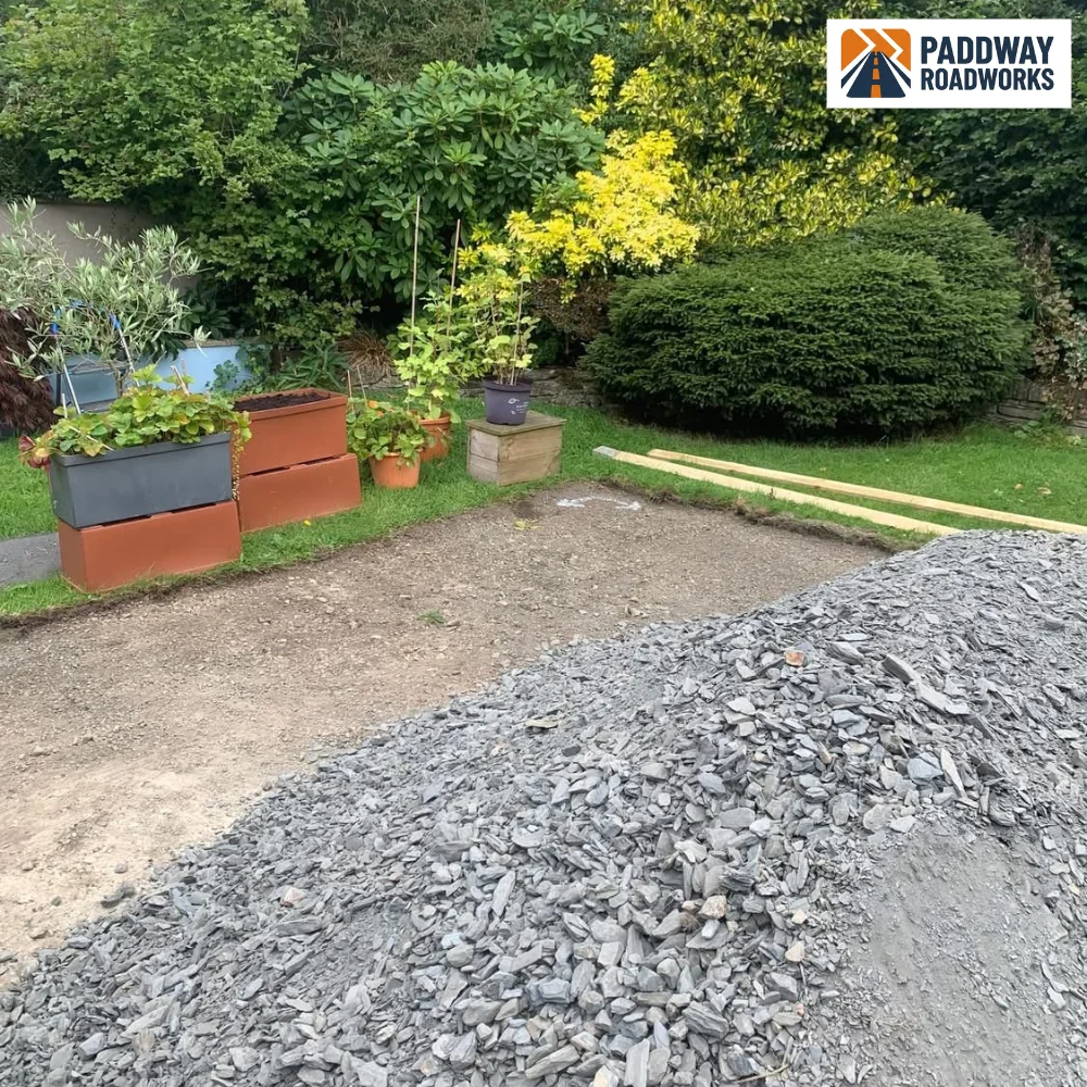 BEFORE — ground prep with stone aggregate piled, ready for tarmac base course.