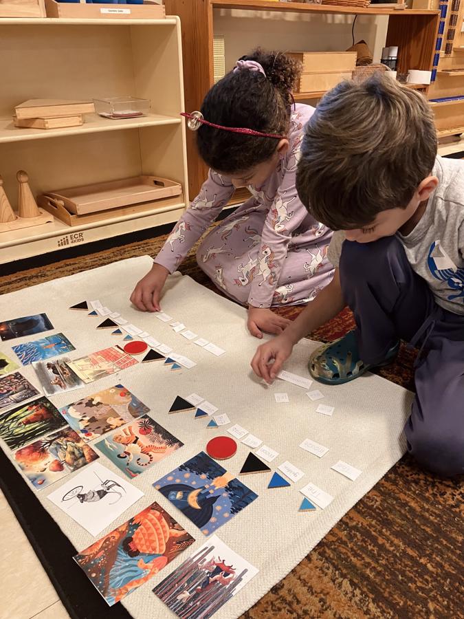 Two children sorting picture cards on a work mat