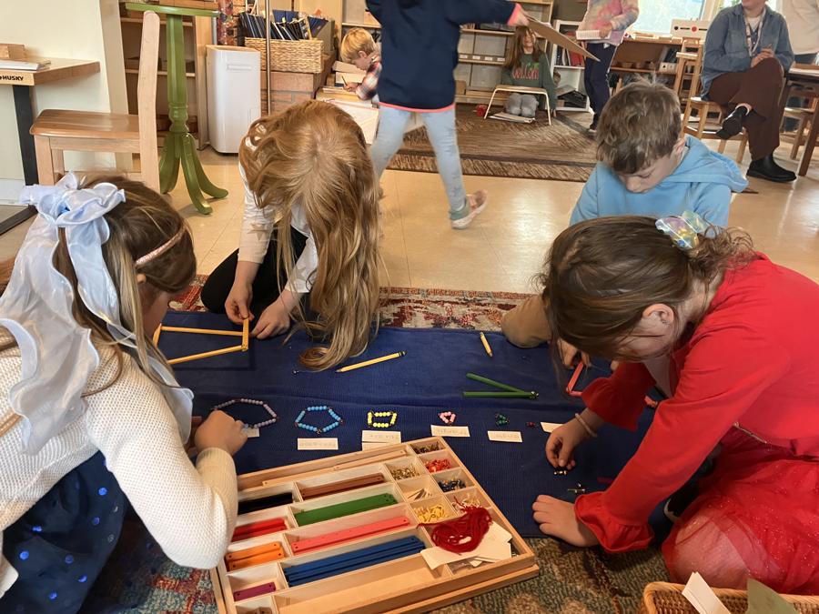 Several children working together on the classroom floor