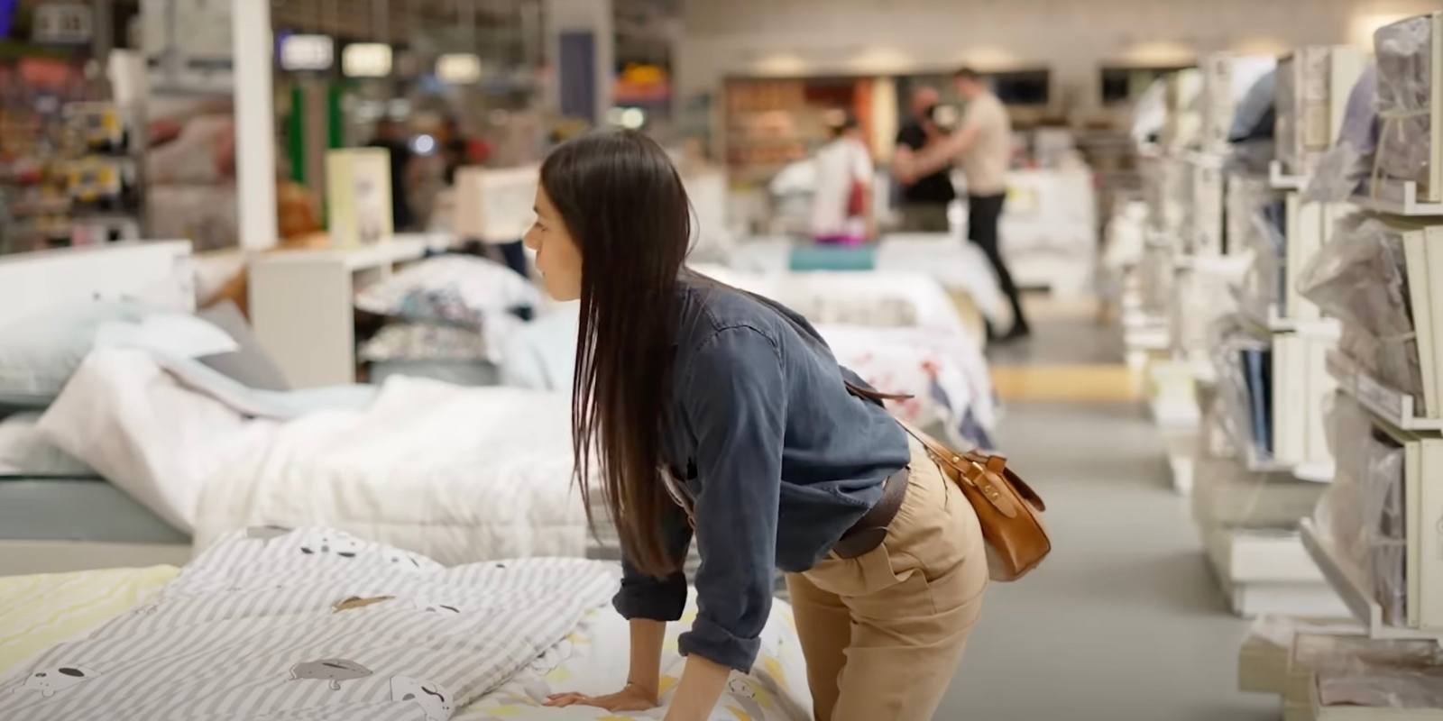 Woman browsing through mattresses in a mattress store Woman browsing through mattresses in a mattress store