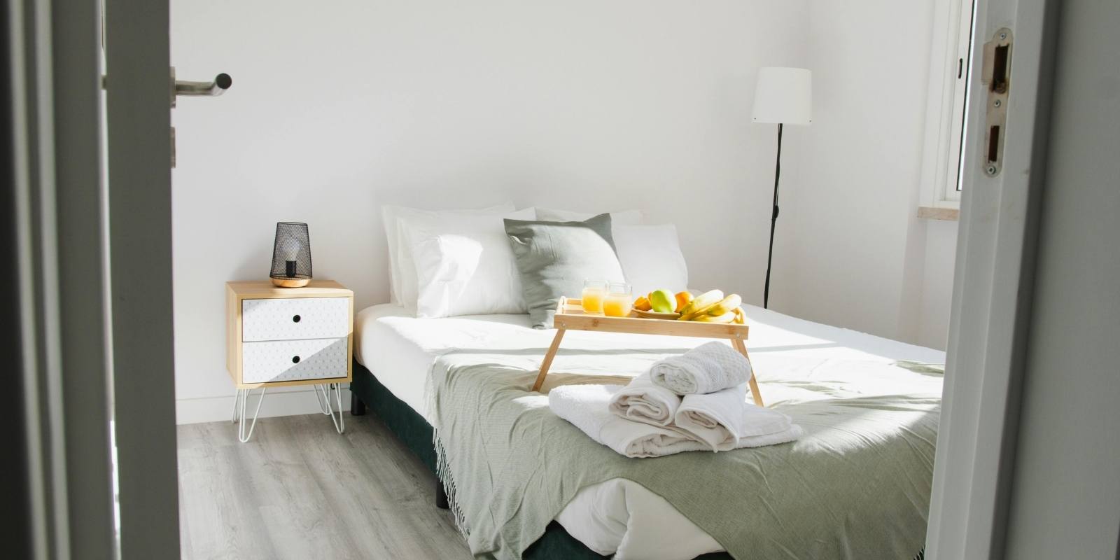A bright and welcoming vacation rental bedroom featuring a high-quality mattress with clean white sheets.