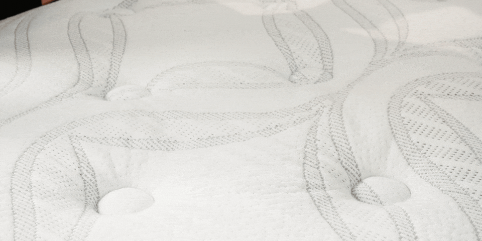 Animation of a hand pressing on a mattress showing how motion is absorbed locally without transferring across the bed
