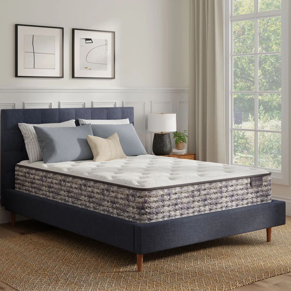 Scott Living Floren Plush mattress on a navy upholstered bed