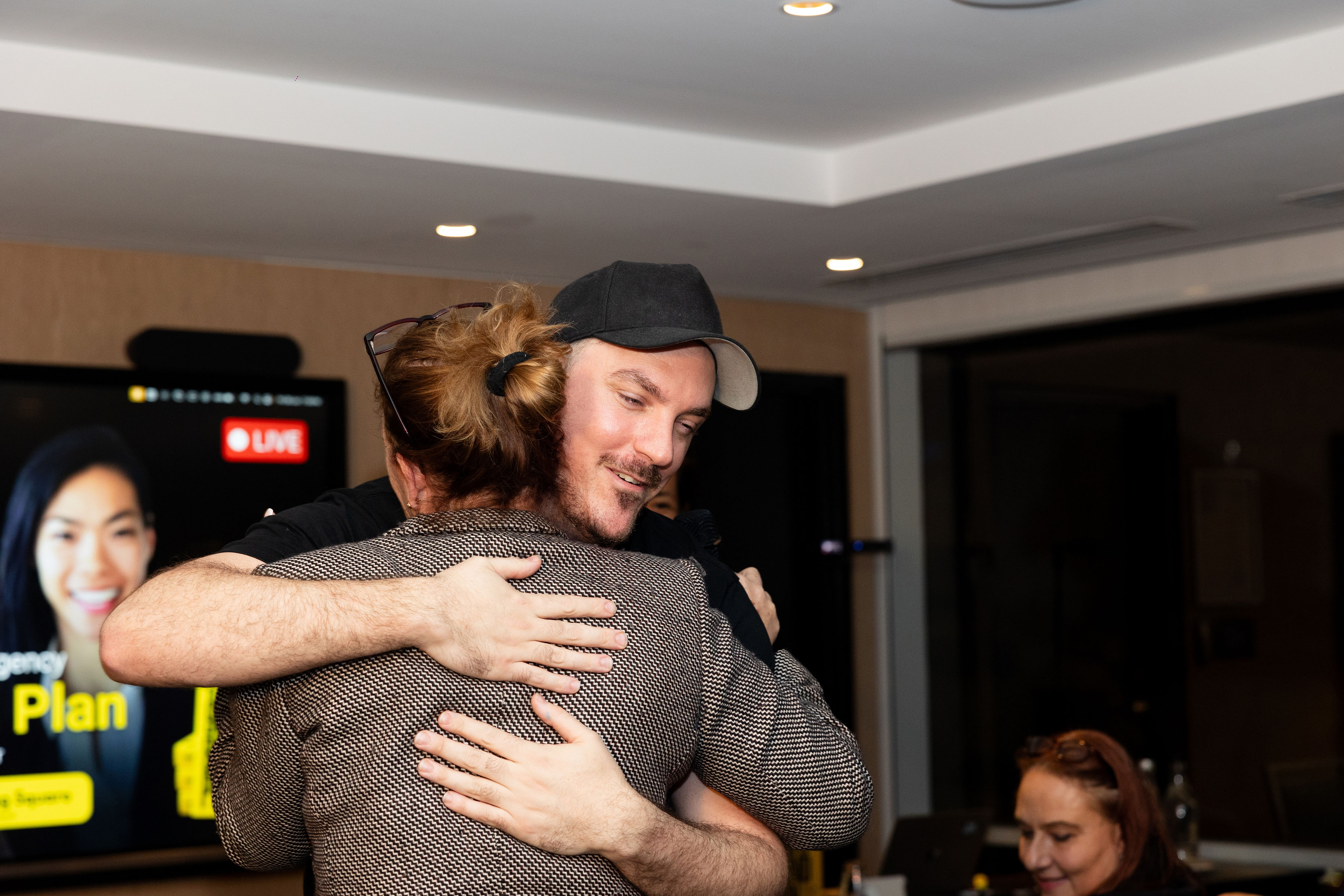 A heartfelt hug, with Karms on the screen behind