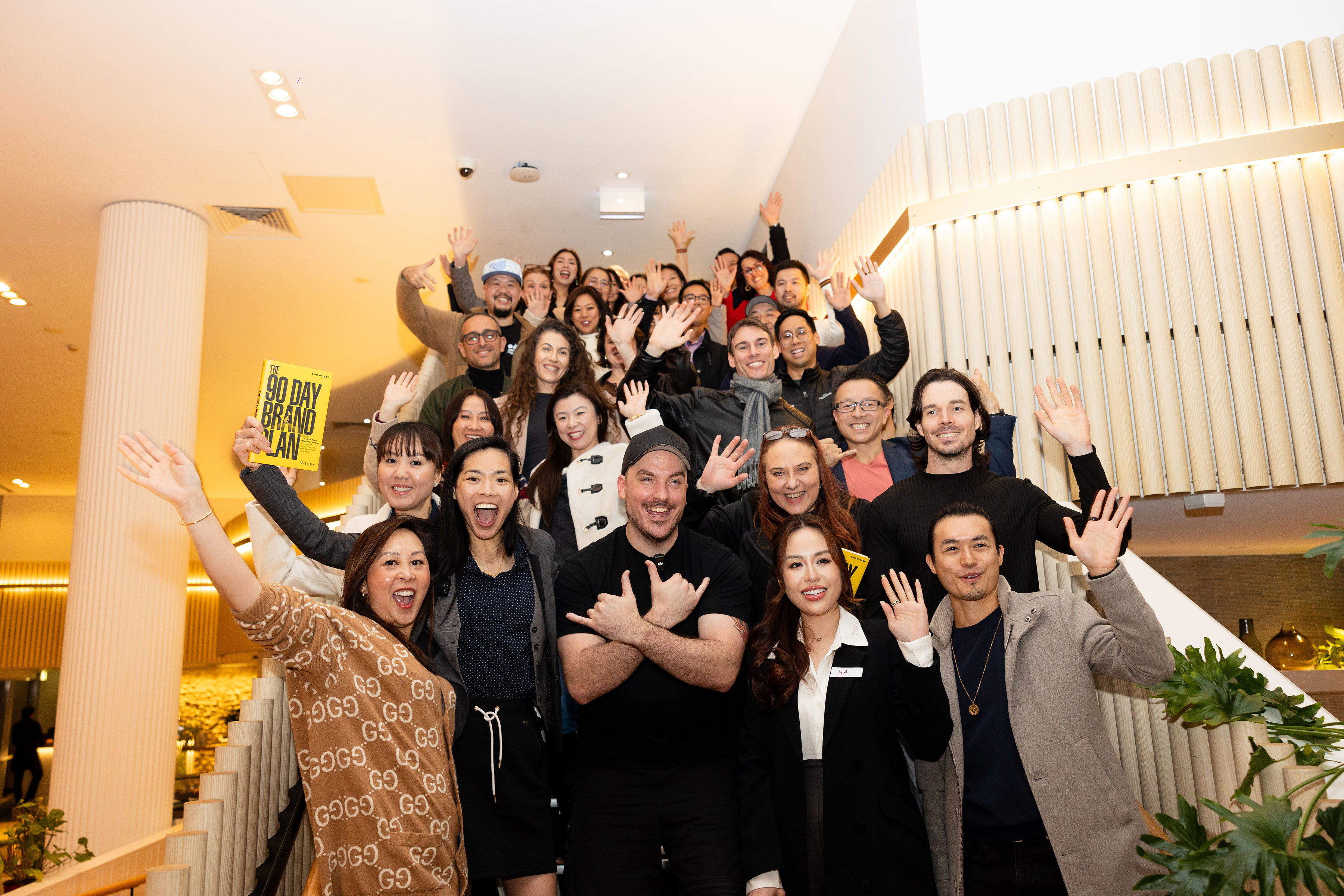 The Sip & Switch community waving on the staircase