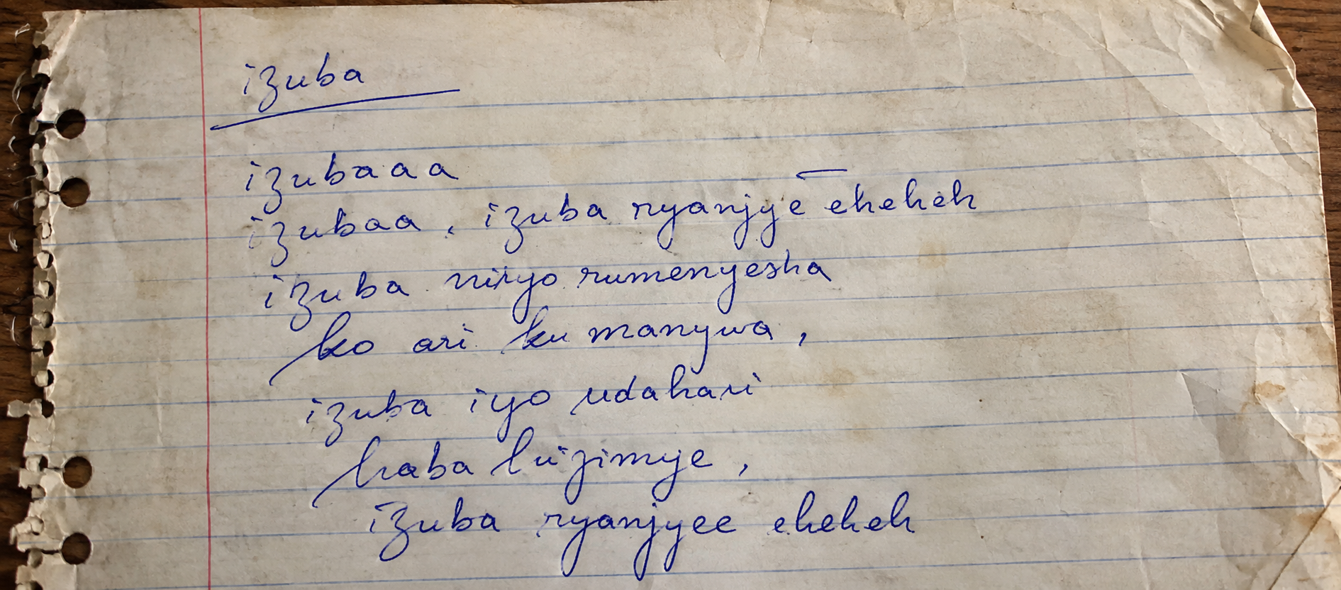 Original handwritten lyrics of the song Izuba on a worn notebook page