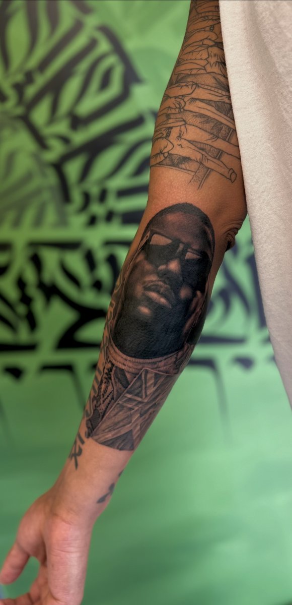 Black and grey portrait forearm tattoo by Aidin Chimney, Manchester