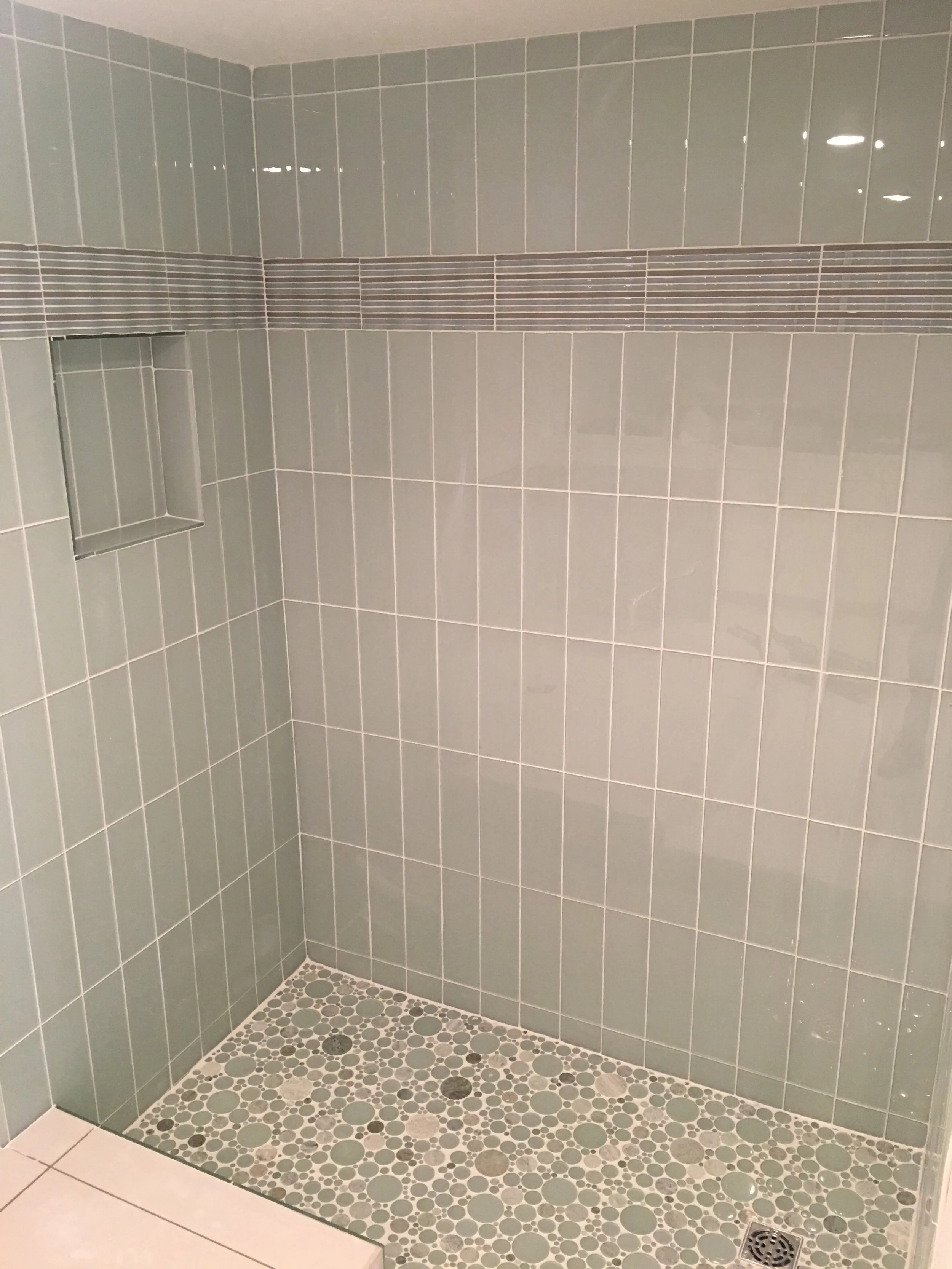 Spa green shower tile with pebble floor