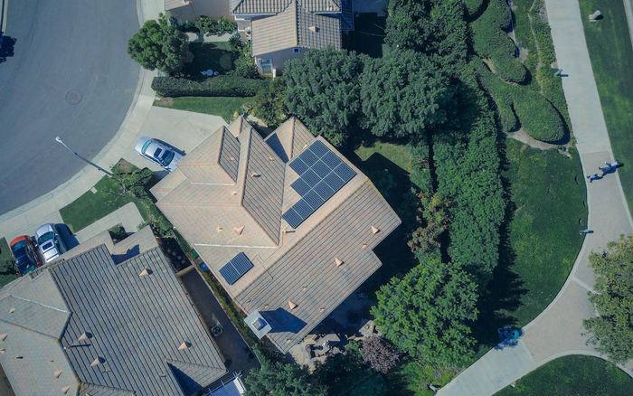 Vista aérea de una vivienda unifamiliar con placas solares en el tejado