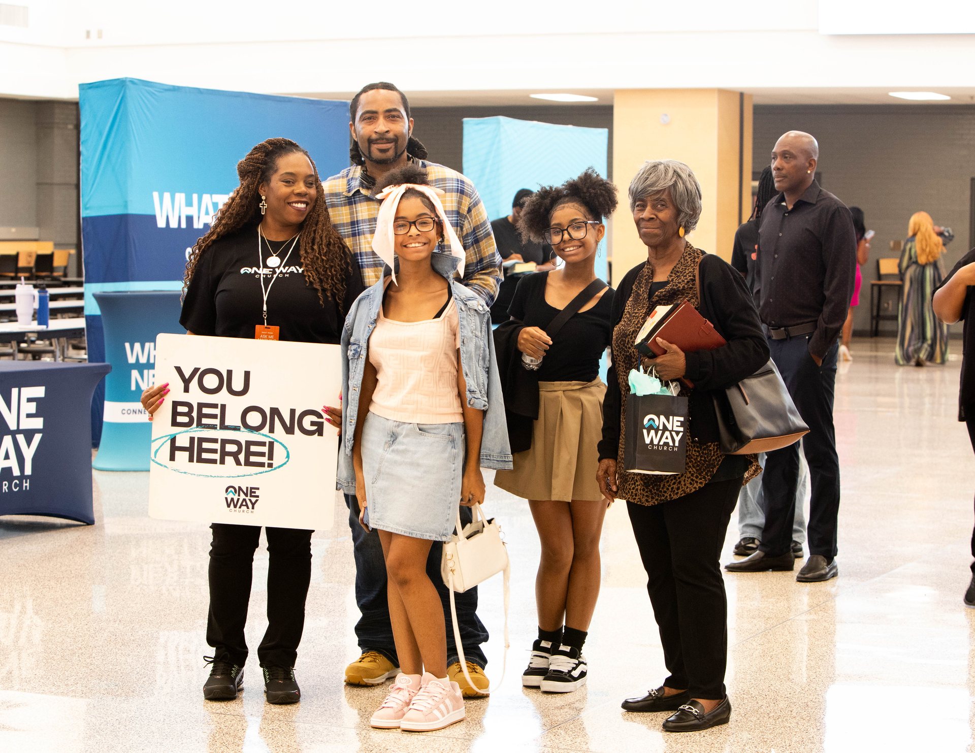 A family holding a You Belong Here sign