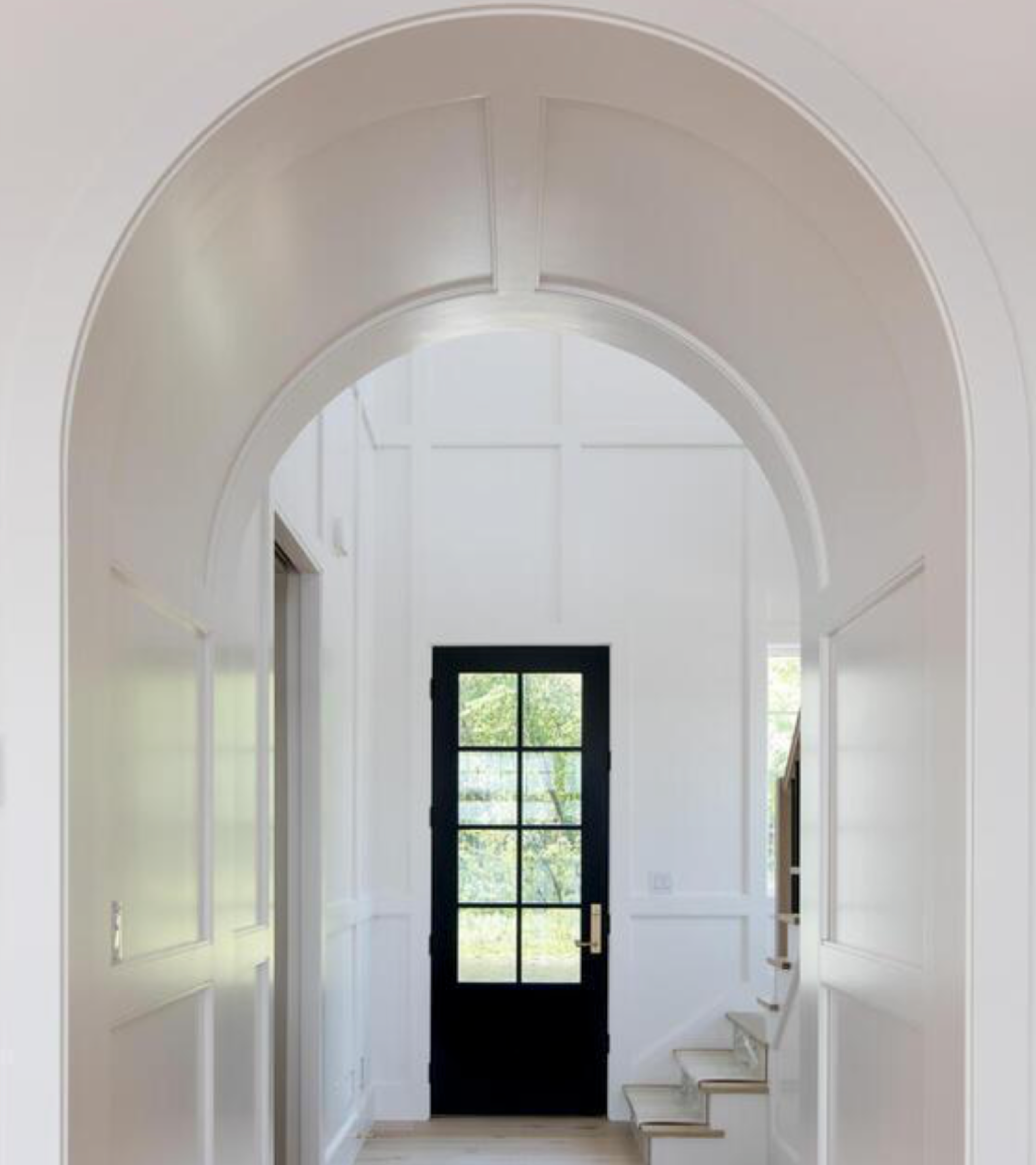 Bright arched entryway with black front door