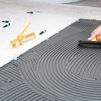 Applying tile mortar with a notched trowel for even adhesion