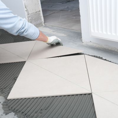 Triangular floor tiles being placed with mortar